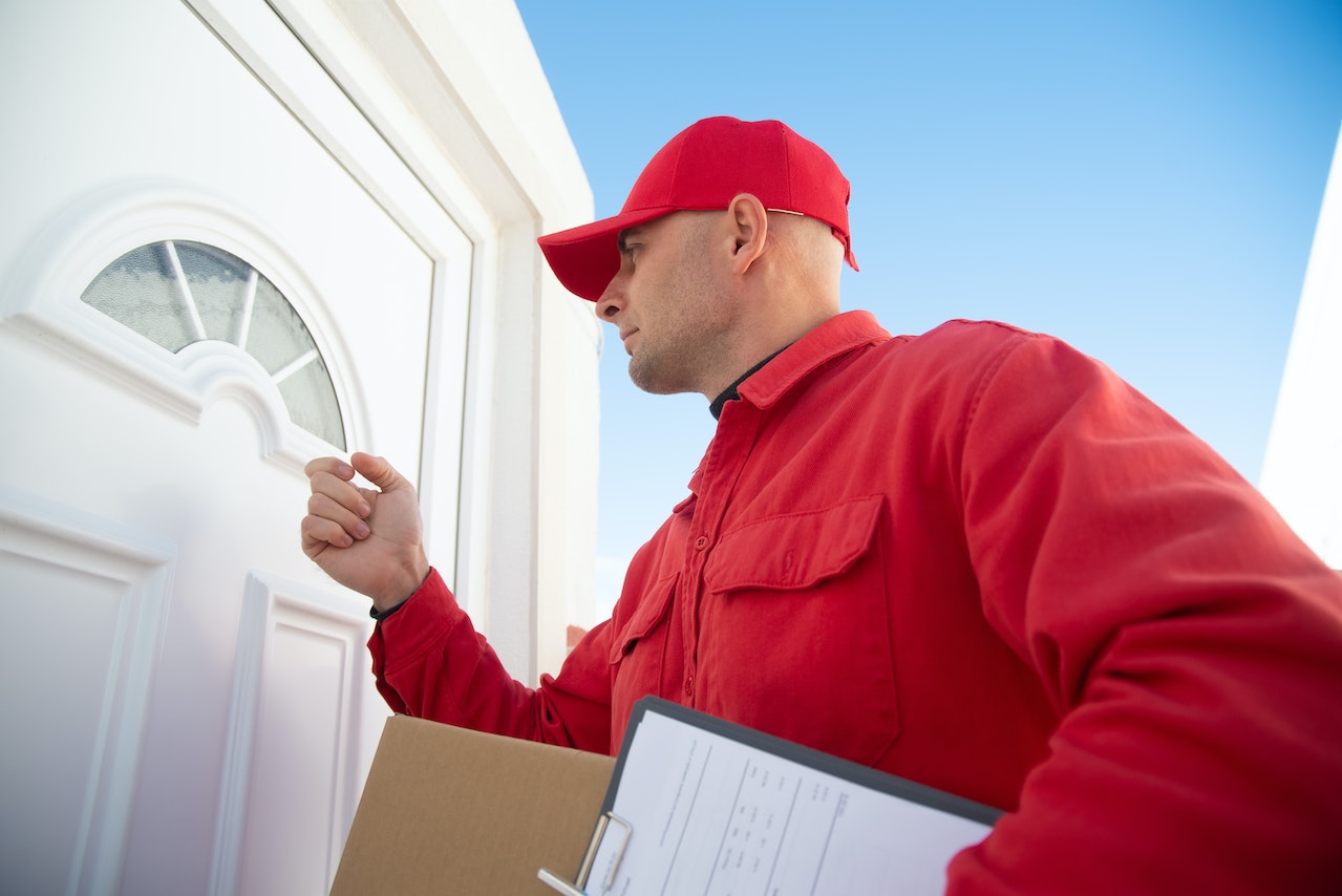 Man Red Shirt Knocking White Door